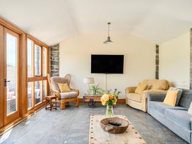 A snug with two sofas and a television at The Barn in Corwen