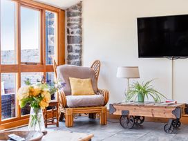 A living room with an armchair and a coffee table at The Barn in Corwen
