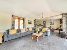 A living room with a sofa and table at The Barn in Corwen