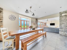 A dining room with a table and bench at The Barn in Corwen