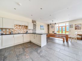 A kitchen with a dining table and chairs at The Barn in Corwen