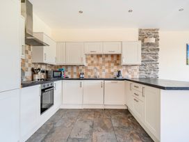A kitchen with cabinets, oven, and microwave at The Barn in Corwen