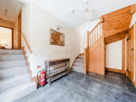 A hallway with stairs and a console table at The Barn in Corwen