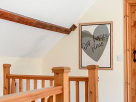 A hallway with wooden railing and a framed picture at The Barn in Corwen