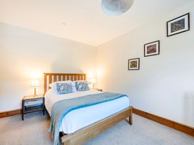 A bedroom with a bed and bedside tables at The Barn in Corwen
