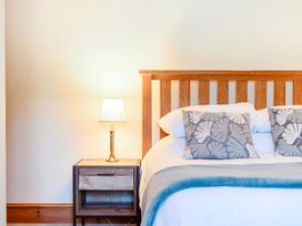 A bedroom with a bed and nightstand at The Barn in Corwen