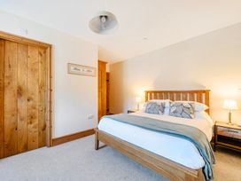 A bedroom with a bed and bedside tables at The Barn in Corwen