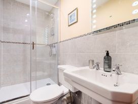 A bathroom featuring a shower, toilet, and sink at The Barn in Corwen
