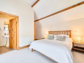 A bedroom with a bed and ensuite bathroom view at The Barn in Corwen