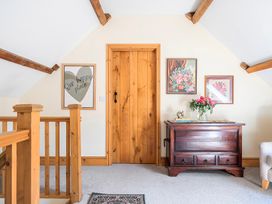A landing area with a wooden door and artwork on the wall at The Barn in Corwen