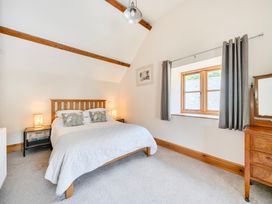 A bedroom with a bed and window at The Barn in Corwen