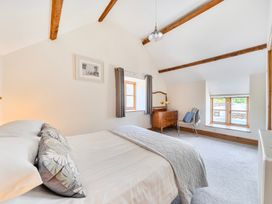 A bedroom with a bed and a window at The Barn in Corwen