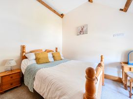 A bedroom with a bed and bedside table at The Barn in Corwen