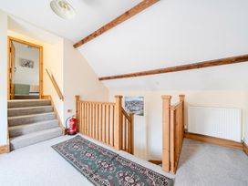 A hallway with a staircase and rug at The Barn in Corwen