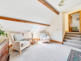 A loft with armchairs and a staircase at The Barn in Corwen