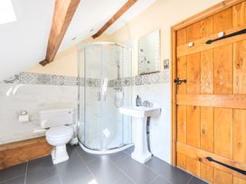 A bathroom with shower, sink and toilet at The Barn in Corwen