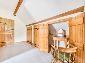 A bedroom with wooden doors and a mirror at The Barn in Corwen