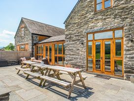 An outdoor patio with a table and chairs at The Barn in Corwen