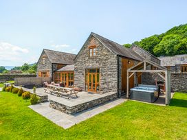 An outdoor area with a hot tub and seating at The Barn in Corwen
