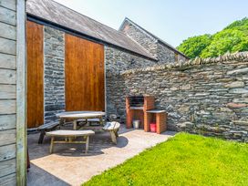 An outdoor space with a table and benches at The Barn in Corwen