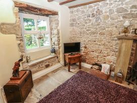 A living room with a television and stone wall at The LA'AL Cragg Kirkby Stephen