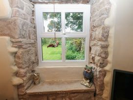 A window with stone wall and owl figurines at The LA'AL Cragg in Kirkby Stephen