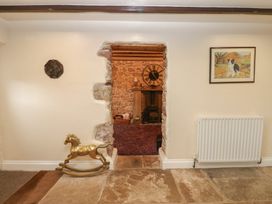 A living room with a rocking horse and a stone wall at The LA'AL Cragg in Kirkby Stephen