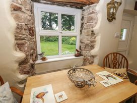 A dining room with a wooden table and window view at The LA'AL Cragg in Kirkby Stephen