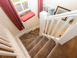 A staircase with a window and books at The LA'AL Cragg in Kirkby Stephen