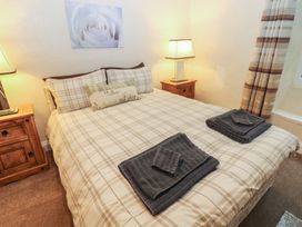 A bedroom with a double bed and bedside table at The LA'AL Cragg in Kirkby Stephen
