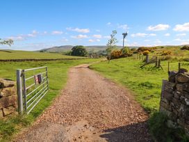 A gravel path leading to a gate with hills in the background at The LA'AL Cragg, Kirkby Stephen