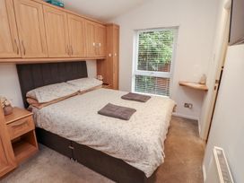 A bedroom with a bed and a window at Willows Lodge White Cross Bay near Windermere