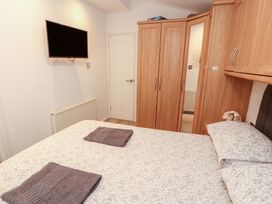 A bedroom with a bed and wardrobe at Willows Lodge near Windermere