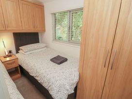 A bedroom with a single bed and a wardrobe at Willows Lodge, White Cross Bay, near Windermere
