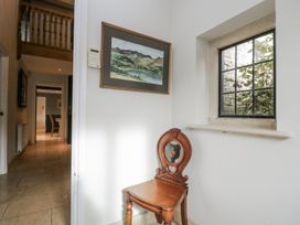 A hallway with a painting and chair at The Old Hall in Tetbury
