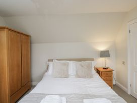 A bedroom with a bed, wardrobe, and bedside table at The Old Hall in Tetbury