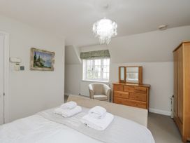 A bedroom with a bed and dresser at The Old Hall in Tetbury
