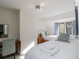 A bedroom with two beds and a desk at The Old Hall in Tetbury