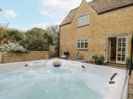 An outdoor area with a hot tub next to a house at The Old Hall in Tetbury