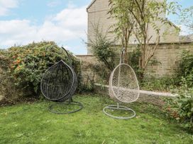 Two hanging chairs in a garden area at The Old Hall in Tetbury