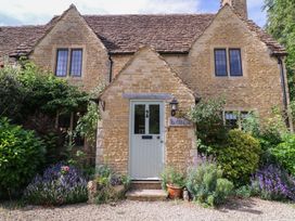 A house with a front door and flowers in the garden at The Old Hall Westonbit Nr Tetbury