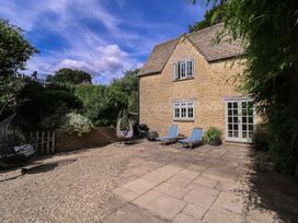 A garden with deck chairs and a hanging chair at The Old Hall Westonbit Nr Tetbury