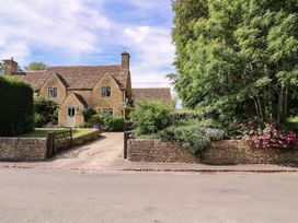 A house with a stone wall and flowers in the front yard at The Old Hall in Westonbit Nr Tetbury