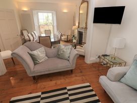 A living room with a sofa and dining area at Scillonia in Penzance