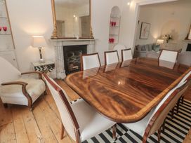 A dining room with a wooden table and chairs at Scillonia in Penzance
