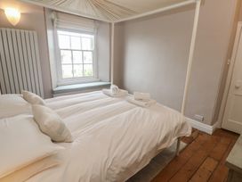 A bedroom with a bed and a window at Scillonia in Penzance