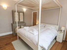 A bedroom with a four-poster bed and wardrobe at Scillonia Penzance