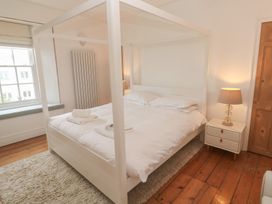 A bedroom with a four-poster bed and lamp at Scillonia in Penzance