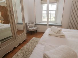A bedroom with towels on the bed and an armchair at Scillonia in Penzance