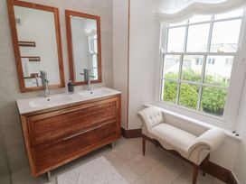 A bathroom with a double sink vanity and mirrors at Scillonia in Penzance